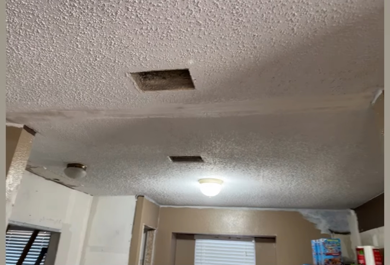 Popcorn ceiling with damaged patches before repair