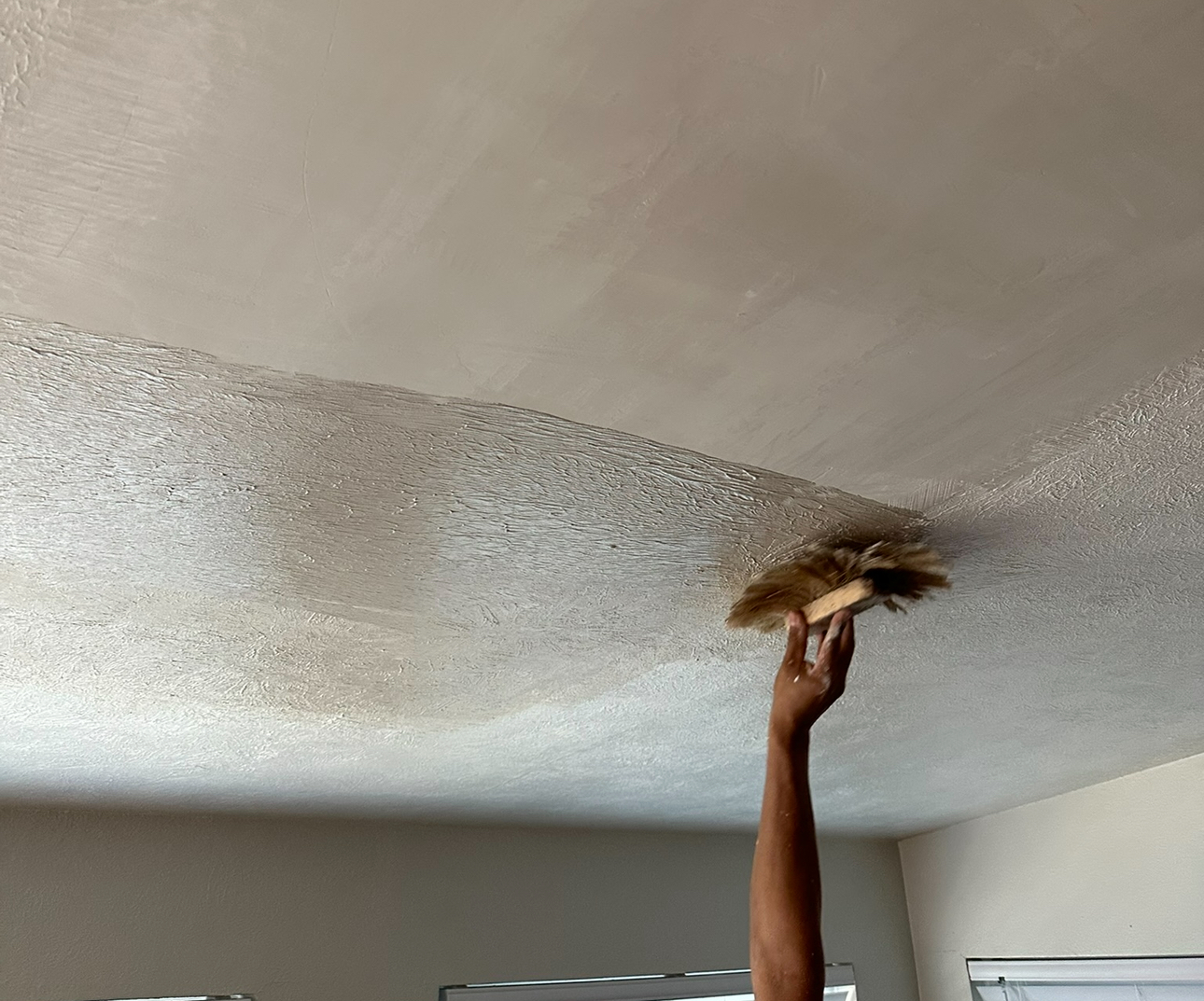Smooth skim-coat ceiling finish in progress