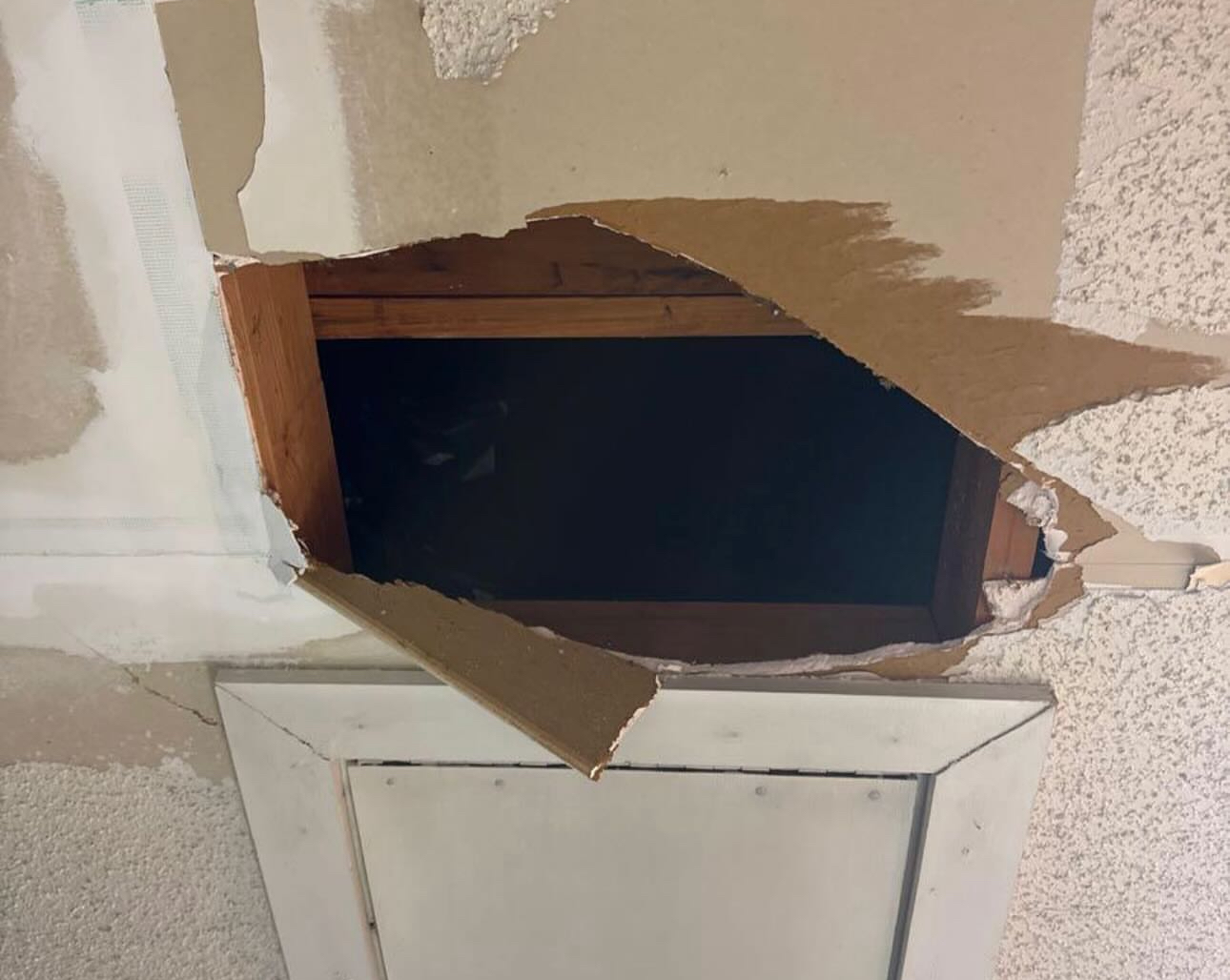 Ceiling drywall damage exposing wood joists before repair